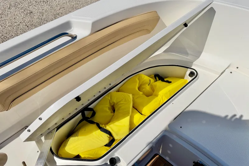 Slide: The Image of Storage compartment with yellow life jackets on a 2023 Bayliner Trophy T24CC boat. - 26
