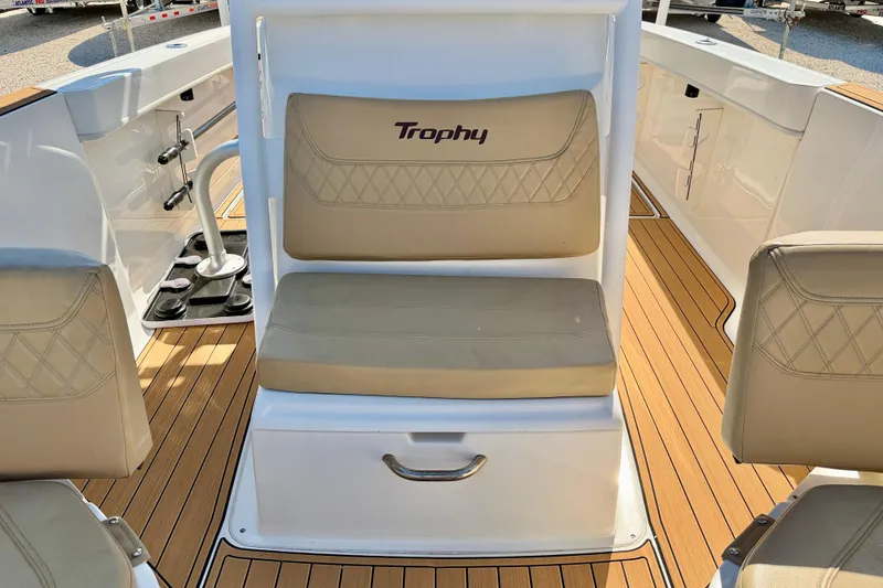 Slide: The Image of 2023 Bayliner Trophy T24CC boat interior with beige seating and wood-style flooring. - 27