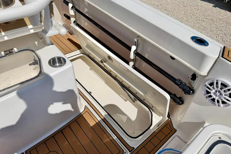 Slide: The Image of 2023 Bayliner Trophy T24CC boat interior with storage compartment and rod holders. - 29