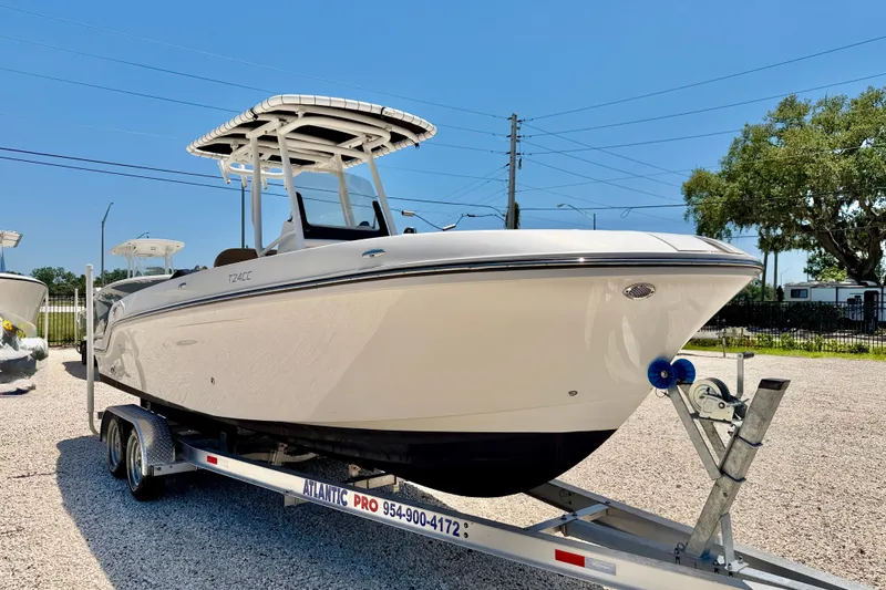 Slide: The Image of 2023 Bayliner Trophy T24CC boat on trailer, displayed outdoors under clear blue sky. - 3