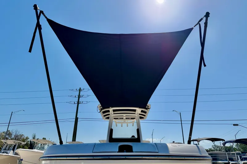 Slide: The Image of 2023 Bayliner Trophy T24CC boat with sunshade against clear blue sky. - 37