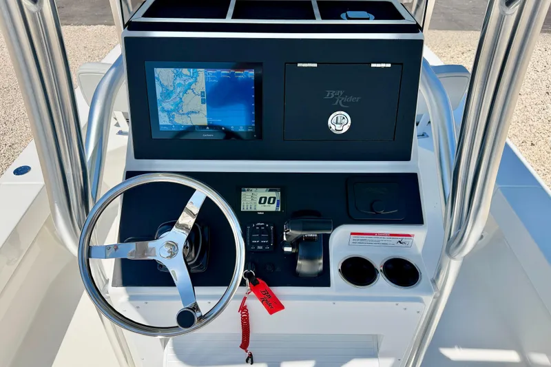 Slide: The Image of 2026 Bay Rider 239 Bay boat console with steering wheel, navigation screen, and controls. - 16