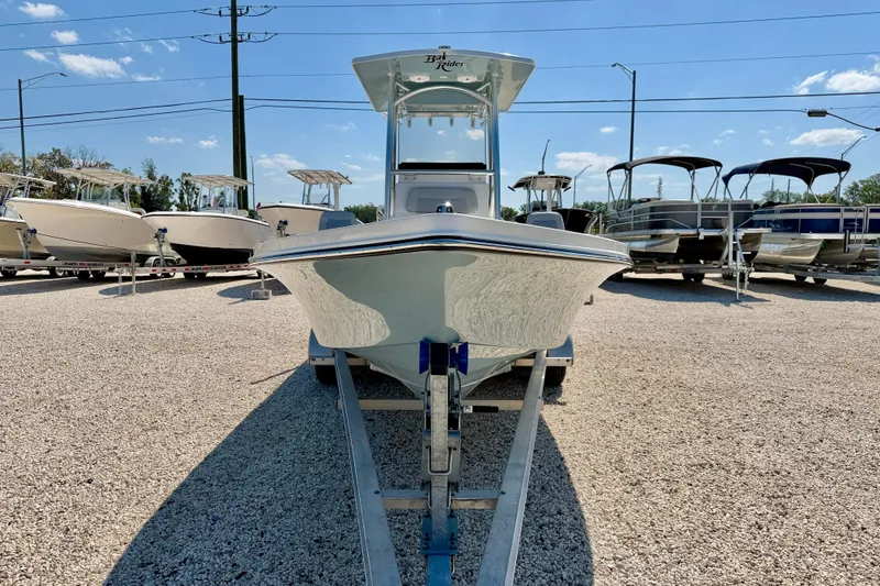 Slide: The Image of 2026 Bay Rider 239 Bay boat on trailer in sunny outdoor showroom. - 2