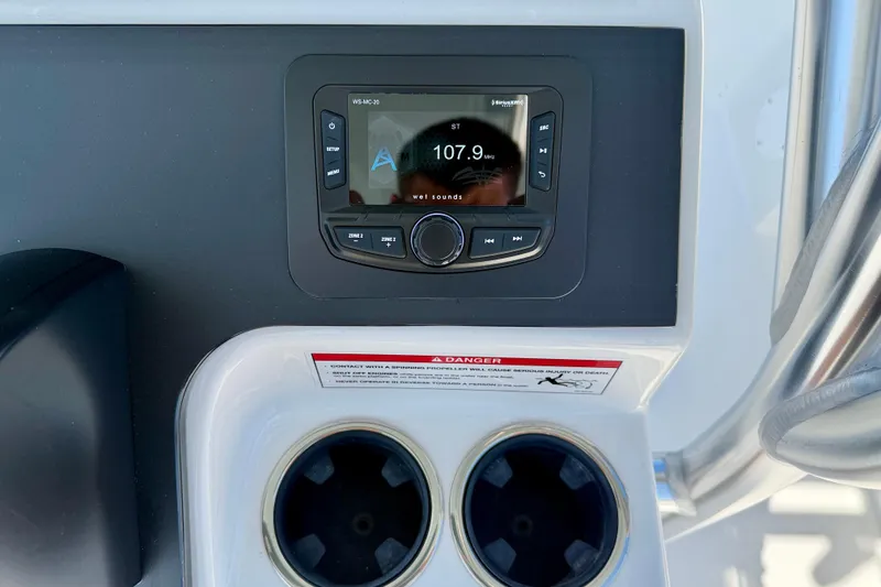 Slide: The Image of 2026 Bay Rider 239 Bay boat dashboard with radio display and cup holders. - 23