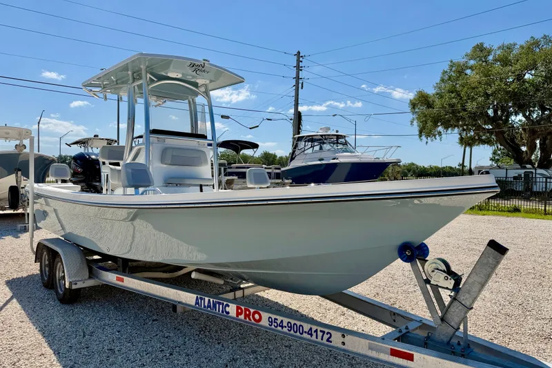Slide: The Image of 2026 Bay Rider 239 Bay boat on trailer in sunny outdoor setting. - 3