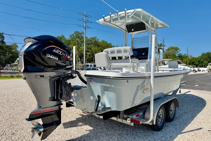 Slide: The Image of 2026 Bay Rider 239 Bay boat with Yamaha engine on a trailer, parked outdoors. - 5