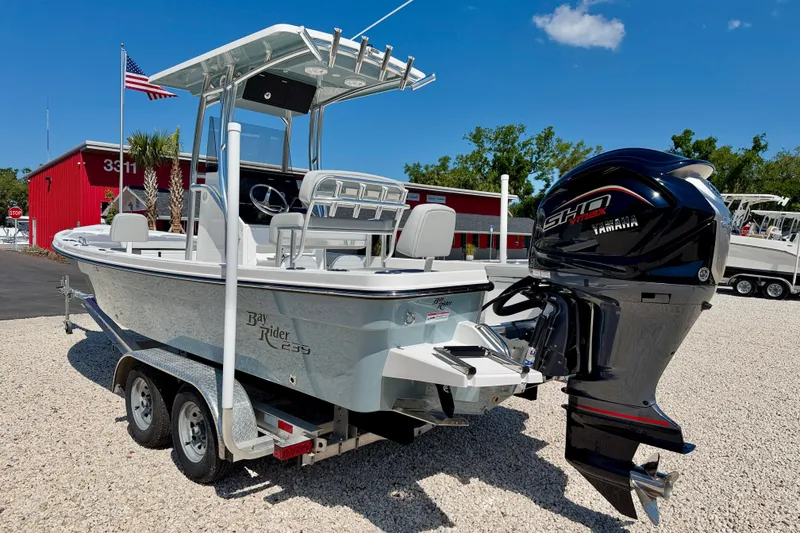 Slide: The Image of 2026 Bay Rider 239 Bay boat with Yamaha engine on trailer, outdoors. - 7