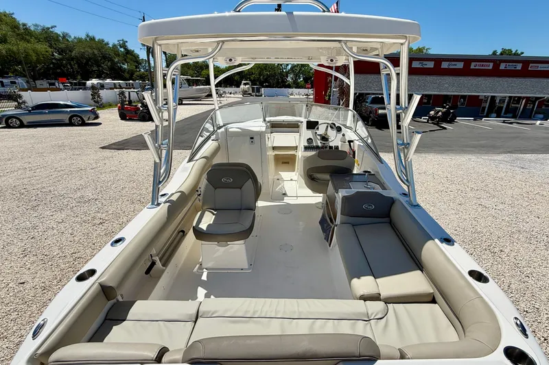 Slide: The Image of 2024 Key West 239 DFS boat interior with seating and helm, parked outdoors. - 13
