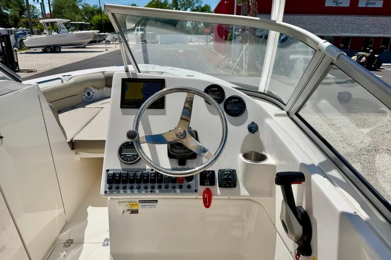 Slide: The Image of 2024 Key West 239 DFS boat dashboard with steering wheel and control panel. - 14