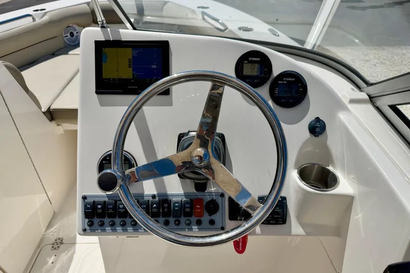 Slide: The Image of 2024 Key West 239 DFS boat dashboard with steering wheel, gauges, and navigation display. - 15
