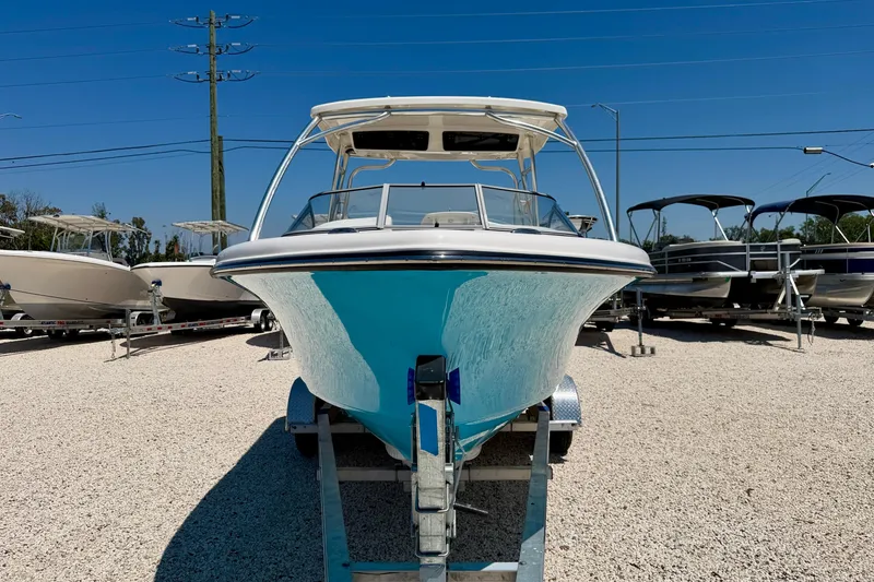 Slide: The Image of 2024 Key West 239 DFS boat on trailer, displayed outdoors under clear blue sky. - 2