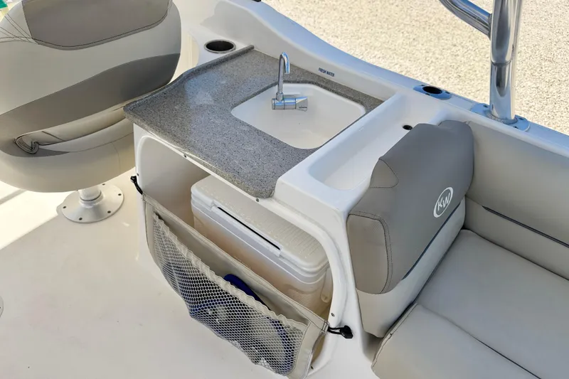 Slide: The Image of 2024 Key West 239 DFS boat interior with sink, seating, and storage area. - 22
