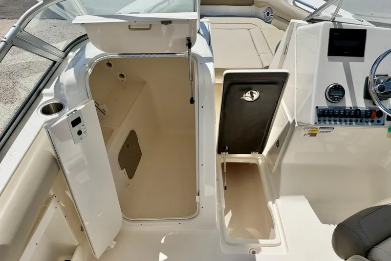 Slide: The Image of 2024 Key West 239 DFS boat interior with open storage compartments and control panel. - 23