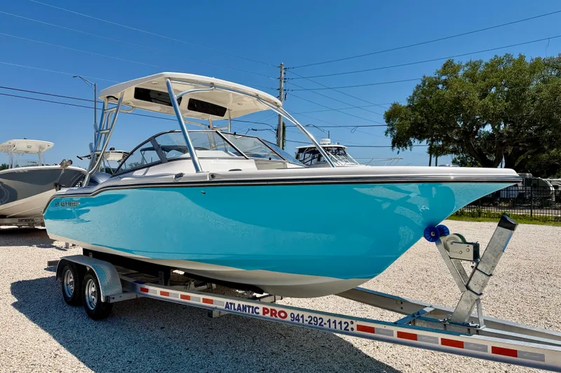 Slide: The Image of 2024 Key West 239 DFS boat on trailer, vibrant blue hull, sunny outdoor setting. - 3
