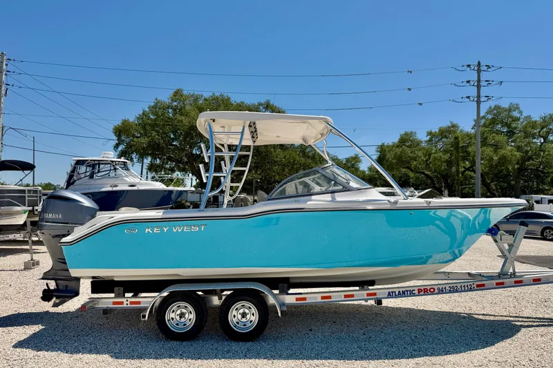 Slide: The Image of 2024 Key West 239 DFS boat on trailer, vibrant blue hull, sunny day. - 4