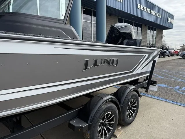 Slide: The Image of 2026 Lund 2075 Impact XS Sport boat on trailer outside a building. - 3