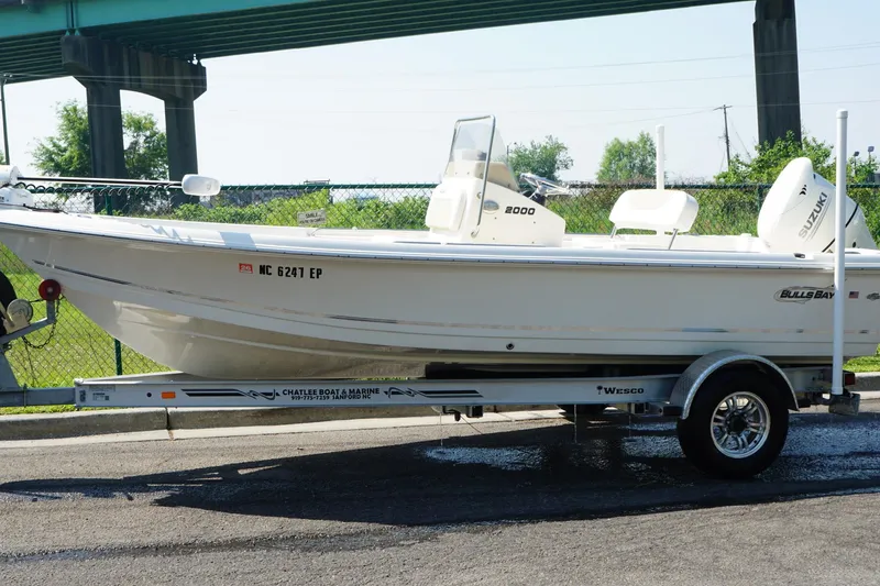 Slide: The Image of 2020 Bulls Bay 2000 boat on trailer, parked outdoors under a bridge. - 10