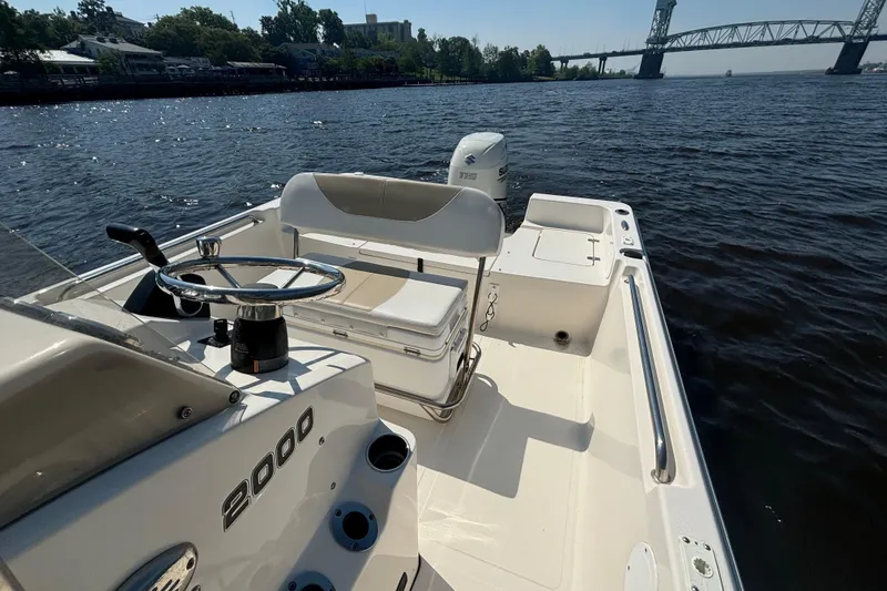 Slide: The Image of 2020 Bulls Bay 2000 boat on water, featuring steering console and seating, near a bridge. - 7