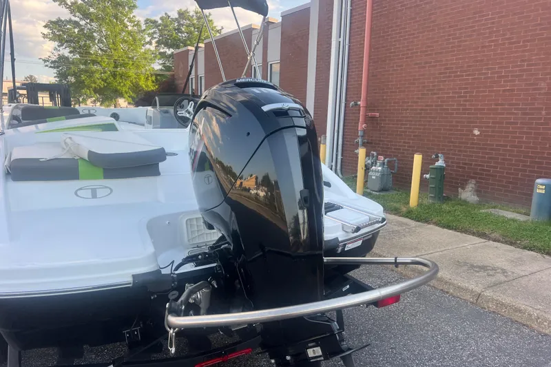 Slide: The Image of 2023 Tahoe T18 boat with Mercury outboard motor, parked near a brick building. - 15