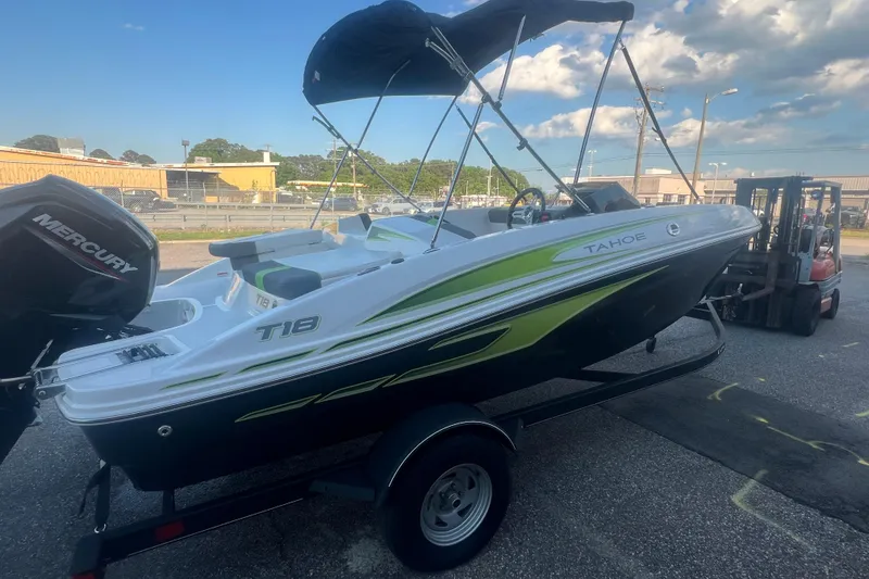 Slide: The Image of 2023 Tahoe T18 boat with canopy on trailer, featuring sleek design and Mercury engine. - 22