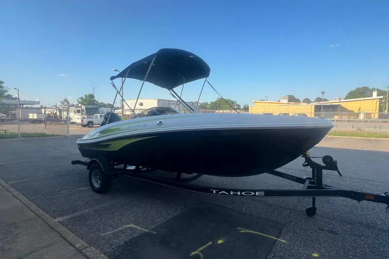 Slide: The Image of 2023 Tahoe T18 boat with canopy on trailer in parking lot. - 23