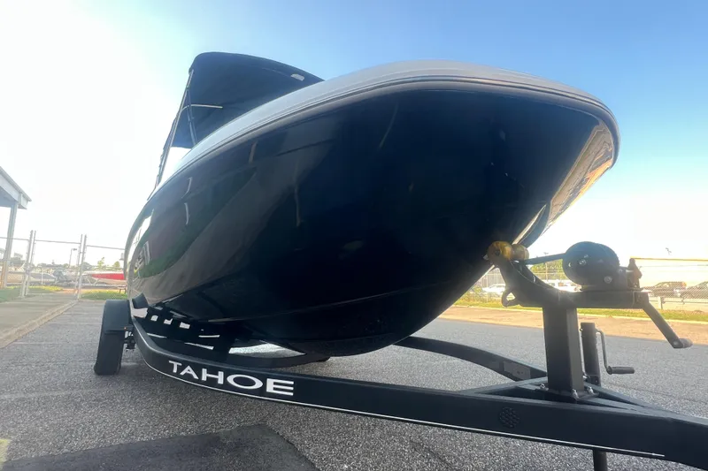 Slide: The Image of 2023 Tahoe T18 boat on trailer, viewed from front angle under clear sky. - 24