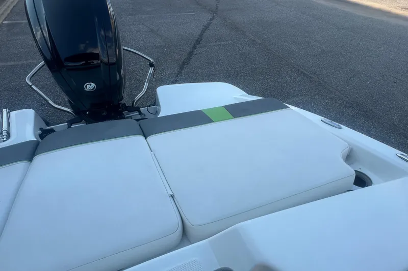 Slide: The Image of 2023 Tahoe T18 boat with cushioned seating and outboard motor on a paved surface. - 36