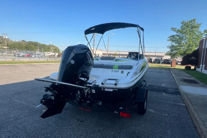 Slide: The Image of 2023 Tahoe T18 boat with outboard motor on a trailer, parked outdoors. - 4