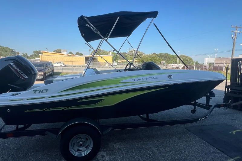 Slide: The Image of 2023 Tahoe T18 boat with canopy on trailer, featuring sleek design and Mercury engine. - 6