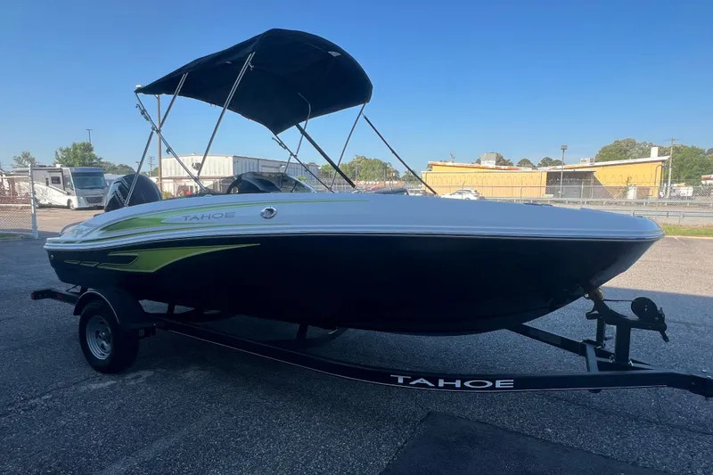 Slide: The Image of 2023 Tahoe T18 boat on trailer with canopy, parked outdoors under clear blue sky. - 7