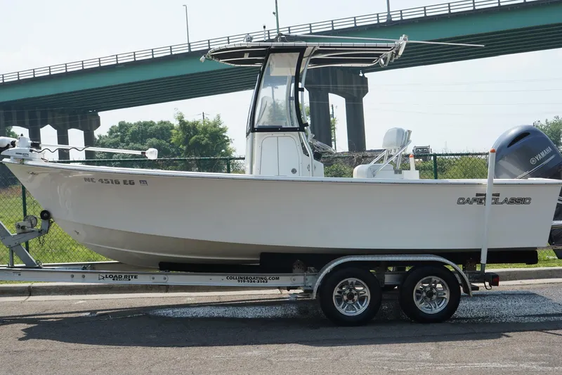 Slide: The Image of 2018 May-Craft 20 Cape Classic boat on trailer, parked near a bridge. - 12
