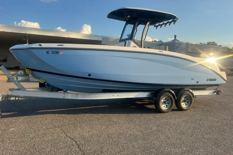 The Image of 2024 Yamaha Boats 255 FSH Sport H on trailer, parked outdoors under clear sky. - 0