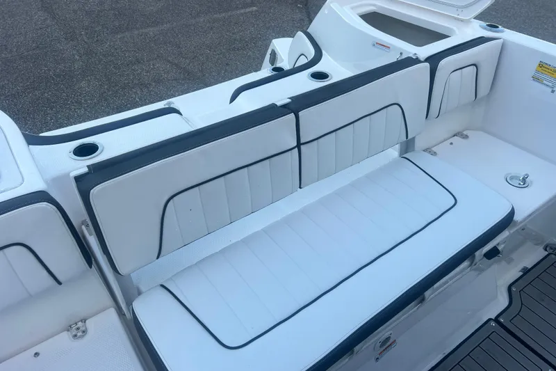 Slide: The Image of 2024 Yamaha Boats 255 FSH Sport H interior seating with white upholstery and cup holders. - 17