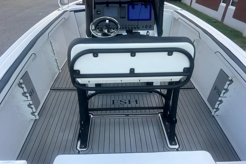Slide: The Image of 2024 Yamaha Boats 255 FSH Sport H interior with steering console and seating. - 2