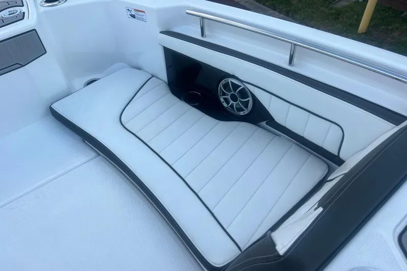Slide: The Image of 2024 Yamaha Boats 255 FSH Sport H interior with cushioned seating and speaker detail. - 23