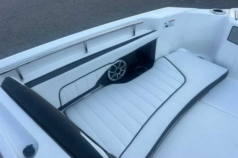Slide: The Image of 2024 Yamaha Boats 255 FSH Sport H interior with white cushioned seating and speaker. - 24