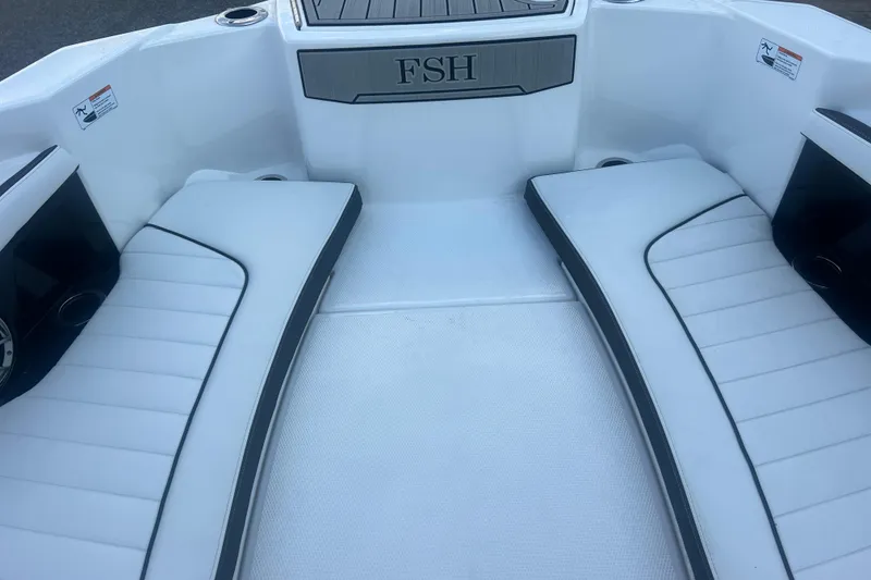 Slide: The Image of 2024 Yamaha Boats 255 FSH Sport H interior seating area with white cushions. - 25
