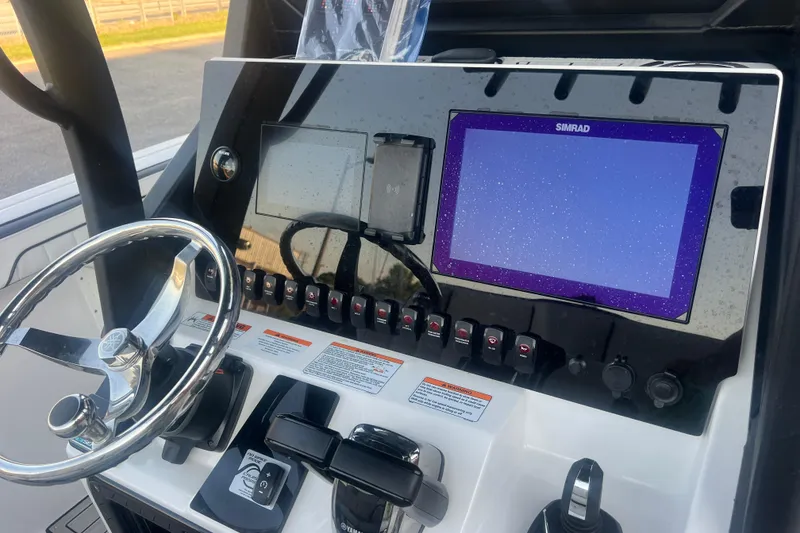Slide: The Image of 2024 Yamaha Boats 255 FSH Sport H dashboard with steering wheel and Simrad display. - 34