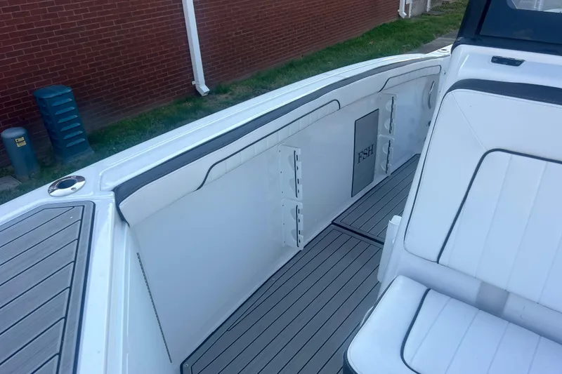 Slide: The Image of 2024 Yamaha Boats 255 FSH Sport H interior with white seating and sleek design. - 38