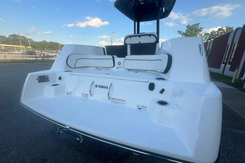 Slide: The Image of 2024 Yamaha Boats 255 FSH Sport H, sleek white design, rear view with seating and cup holders. - 56