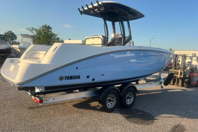 Slide: The Image of 2024 Yamaha Boats 255 FSH Sport H on trailer, side view in outdoor setting. - 63
