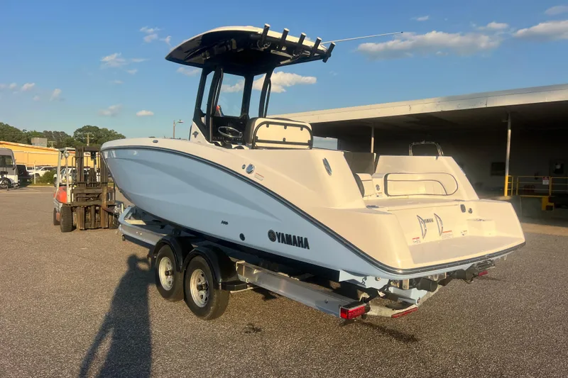 Slide: The Image of 2024 Yamaha Boats 255 FSH Sport H on trailer, parked outdoors under clear sky. - 65