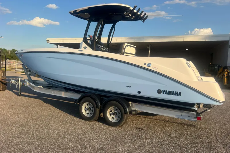 Slide: The Image of 2024 Yamaha Boats 255 FSH Sport H on trailer, side view under clear sky. - 67