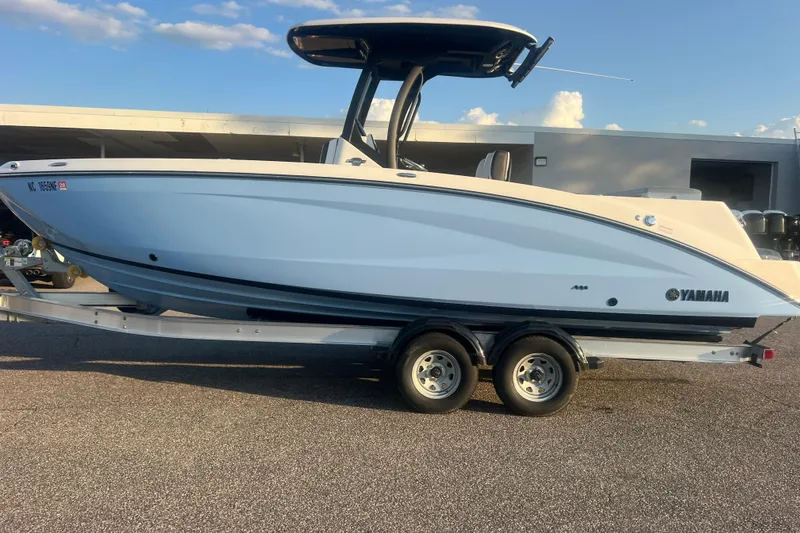 Slide: The Image of 2024 Yamaha Boats 255 FSH Sport H on trailer, side view under clear sky. - 68