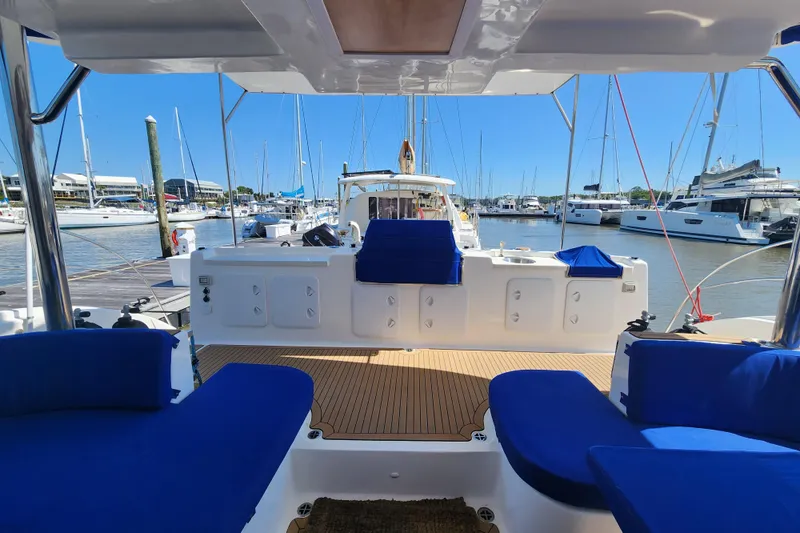Slide: The Image of Luxurious 2021 Royal Cape Catamarans Majestic 570 docked, featuring spacious deck and blue seating. - 11
