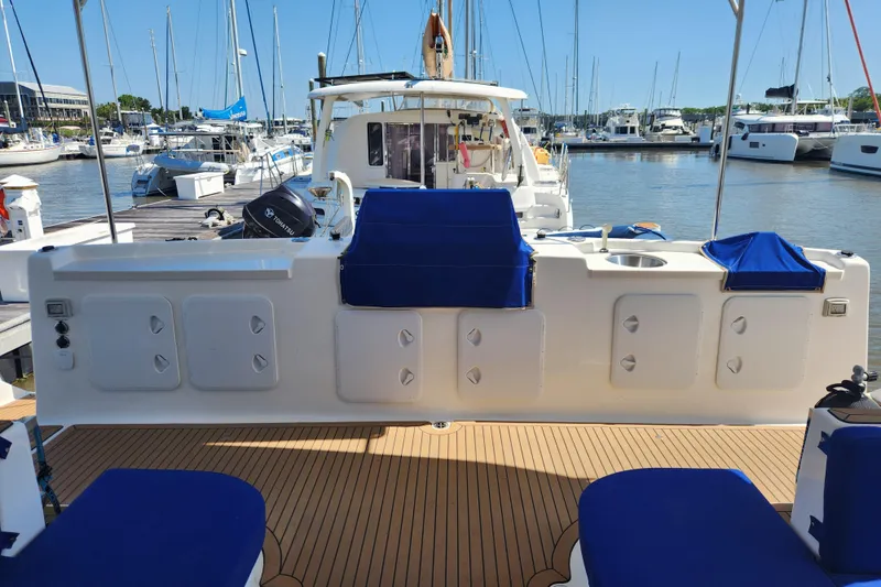 Slide: The Image of 2021 Royal Cape Catamarans Majestic 570 docked, featuring spacious deck and seating area. - 12