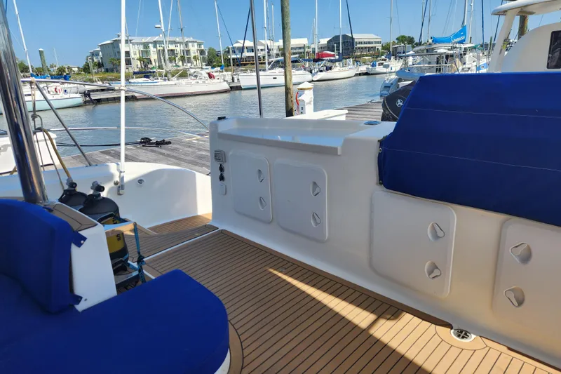 Slide: The Image of 2021 Royal Cape Catamarans Majestic 570 docked, featuring spacious deck and blue seating. - 13