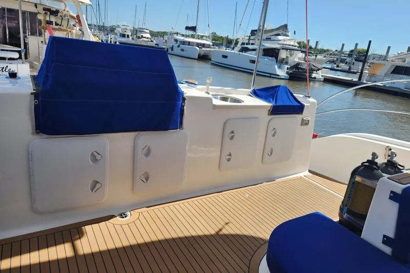 Slide: The Image of 2021 Royal Cape Catamarans Majestic 570 deck with blue covers and marina view. - 14