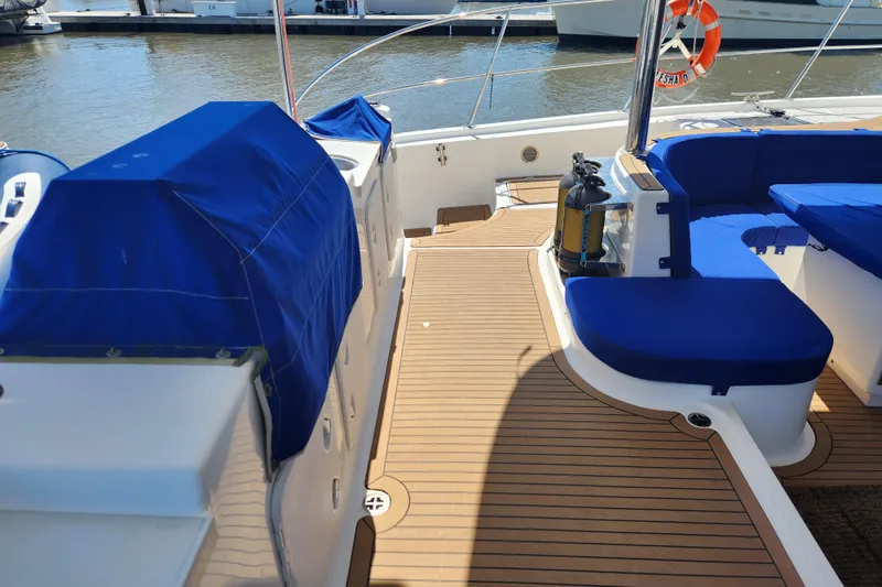 Slide: The Image of Luxurious deck of 2021 Royal Cape Catamarans Majestic 570 with blue seating and wood finish. - 15