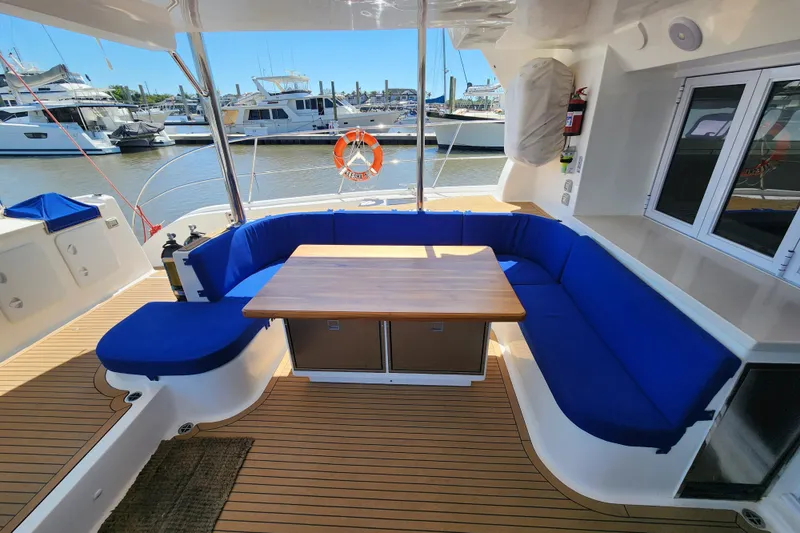 Slide: The Image of Luxurious 2021 Royal Cape Catamarans Majestic 570 with blue seating and wooden table in marina. - 19